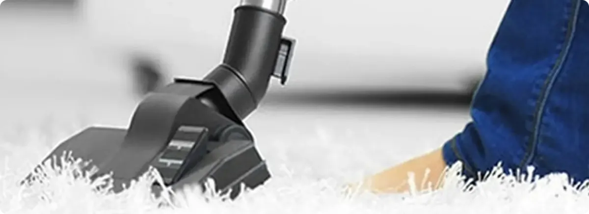 Close-up of a professional vacuuming a white carpet in Hoagland.